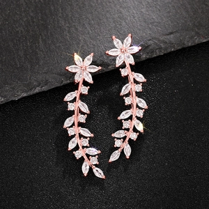 Detailed macro view of rose gold leaf earrings with sparkling zircon stones