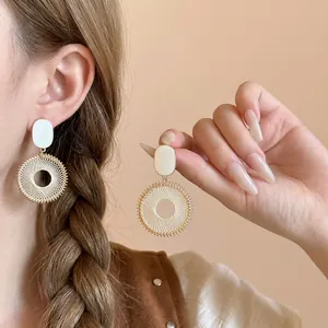 Bohemian style hoop earrings with woven mesh pattern and white oval stud on model