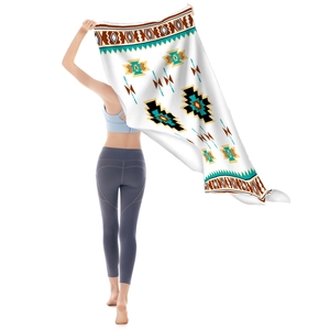 Microfiber beach towel with bohemian geometric pattern held up by a model on white background