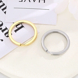Close-up of minimalist gold and silver stainless steel keychains on a clean desk