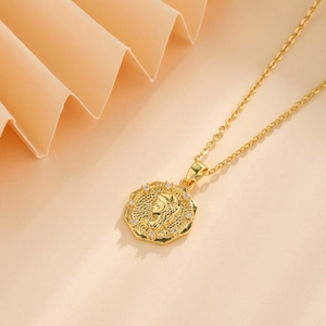 Close-up of 18k gold coin pendant with portrait relief and small zircon inlay detail