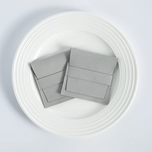 Detail of two gray microfiber suede jewelry pouches with a fold-over flap design