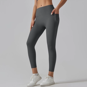 Detail view of high waisted dark grey yoga leggings with functional side pockets