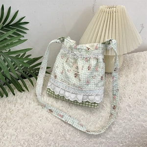 Detailed close-up of light green plaid cartoon crossbody bag with delicate lace trimmings