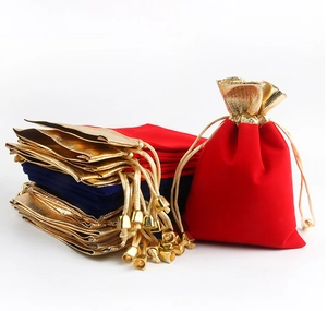 Detail of red and navy velvet drawstring jewelry pouches with gold trim and metal beads