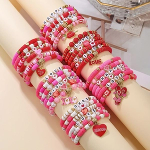 Pink and red stacked clay bead bracelets with LOVE and KISS ME charms for Valentine's Day