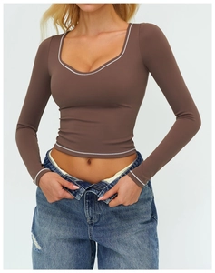 Dettaglio del crop top yoga marrone scuro con bordino bianco su scollatura a U e orlo