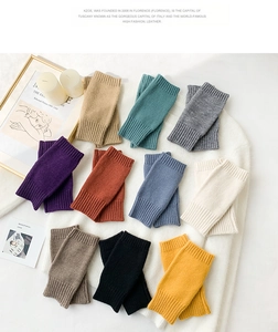 Detailed flat lay of knitted fingerless arm warmers in various pastel and warm colors