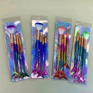 Detail of 4-piece mermaid makeup brush sets in plastic packaging with gradient fishtail handles