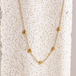 Detail of 18K gold plated stainless steel O-chain necklace with 3D heart pendants on stone