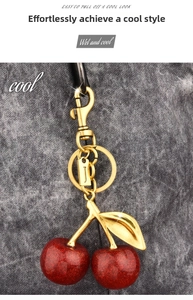 Close-up of red glitter cherry keychain with gold metal leaf and letter J pendant