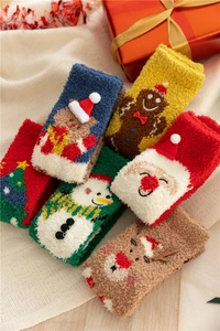 Close-up of thick coral fleece Christmas socks featuring festive holiday embroidery