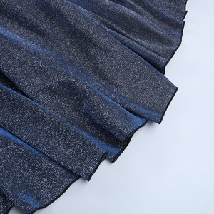 Détail macro du tissu bleu scintillant avec plis métalliques pour robe de cocktail