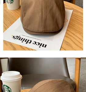 Detailed close-up of brown newsboy cap twill fabric texture on a vintage table
