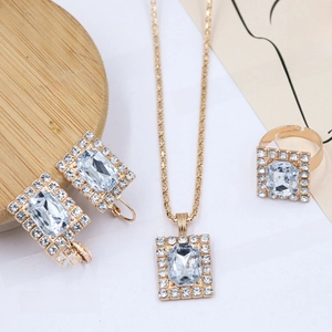 Close-up of elegant gold plated jewelry set with rectangular crystal and pavé diamonds