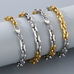 Detail of gold and silver steel link bracelets with lobster clasps on gray background
