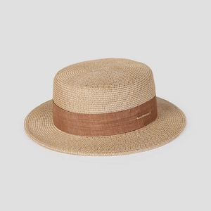 Détail du tressage de paille fine et ruban marron avec plaque en métal doré sur le chapeau