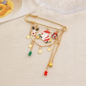 Detail of golden Christmas safety pin brooch with Santa Claus, elk, and gift box charms