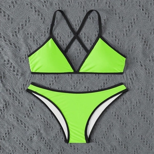 Flat lay of neon green bikini set with black contrast trim and crisscross back straps