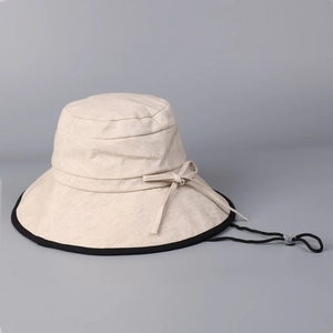 Beige cotton linen sun hat with black trim and adjustable chin strap for women