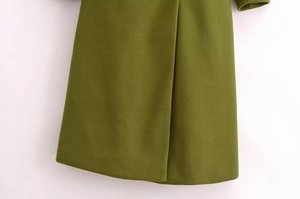 Dettaglio dell'orlo del cappotto di lana verde con spacco posteriore e tessuto spesso