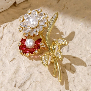 Macro view of gold flower brooch with white and red zircons and delicate pearls