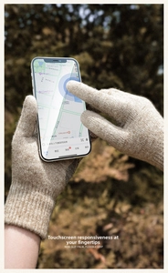 Close-up of beige thermal knit gloves with touchscreen capability for smartphone use