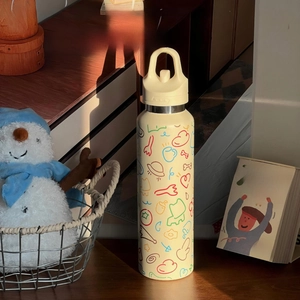Nahaufnahme der cremefarbenen Edelstahlflasche mit Line-Art und ergonomischem Griff
