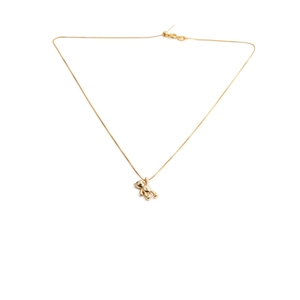 Macro detail of a 3D gold bear pendant with fine chain on a clean white background