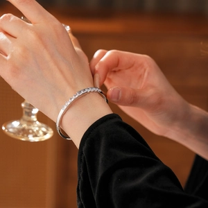 Détail d'un bracelet cœur irrégulier en zircone argentée porté sur un poignet féminin