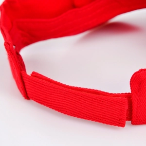 Detailed macro view of the adjustable red velcro strap on a children's sun visor hat