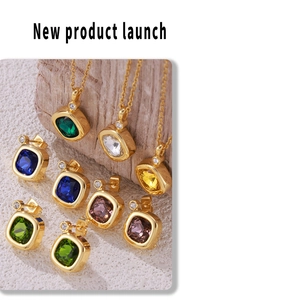Close-up of golden jewelry set with colorful square gemstones on a textured surface