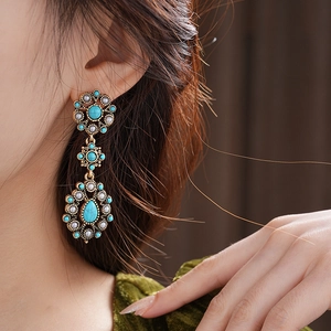 Detail of vintage turquoise drop earrings with faux pearls on bronze metal base