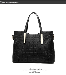 Close-up of black crocodile pattern faux leather tote bag with gold metal hardware details
