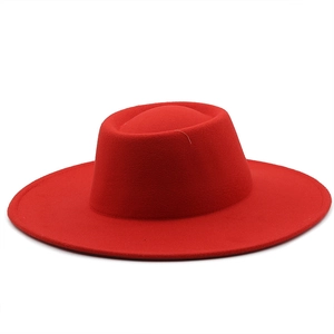 Detail of red wool boater hat with flat top and wide brim for autumn and winter