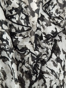 Detail der Rüschenkanten und des monochromen abstrakten Drucks auf Chiffonstoff