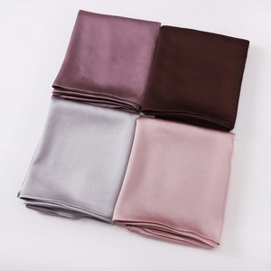 Folded chiffon silk shawls in purple, brown, silver gray, and pink on a white background