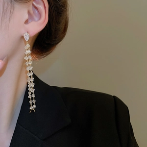 Detail view of long tassel earrings with 18k gold plating and sparkling crystal accents