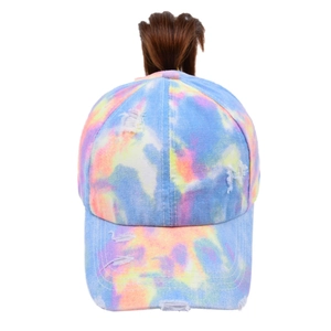 Detailed view of tie-dye baseball cap with distressed holes and high ponytail hole