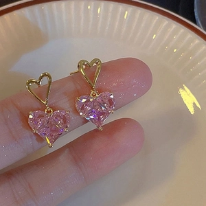 Detailed close-up of pink heart zircon earrings with gold-plated finish on a white tray