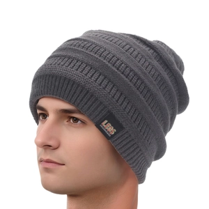 Detail shot of men's dark grey knitted beanie showing soft ribbed texture and brand label