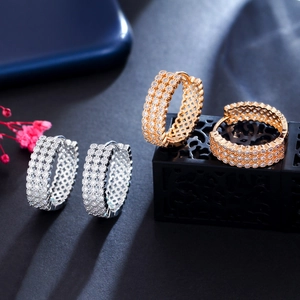 Detailed view of gold and silver hoop earrings with pavé-set zircon and hollow design