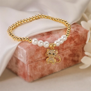 Dettaglio di bracciale con perle e ciondolo gatto in zircone su scatola di velluto rosa