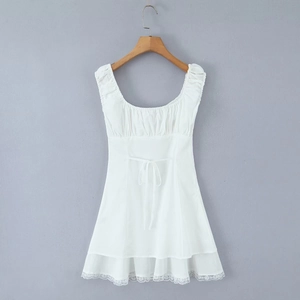 Detail of white sleeveless mini dress featuring lace hem and waist tie on wooden hanger