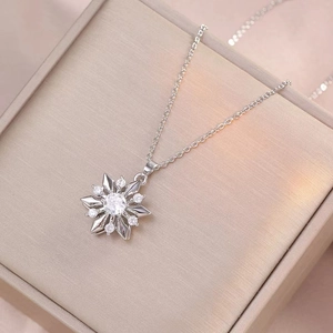 Elegant silver snowflake pendant necklace with cubic zirconia on a jewelry box display