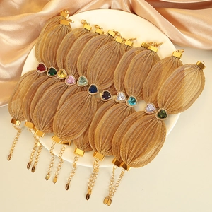 Gold mesh link bracelet with heart-shaped colorful zircons on luxury silk background