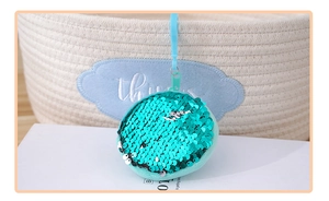 Detail of mint green sequin coin purse with matching hook on a white surface