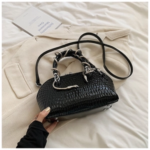 Close-up of black crocodile pattern shell bag with unique silver snake-shaped handle