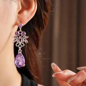 Close-up of vintage silver teardrop amethyst earrings worn by a model in luxury style