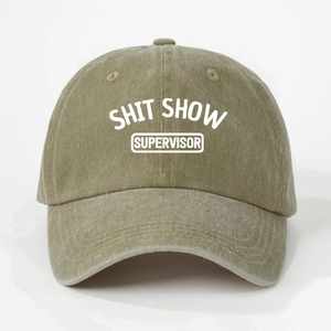 Détail de l'imprimé SHIT SHOW SUPERVISOR sur une casquette en coton kaki délavé